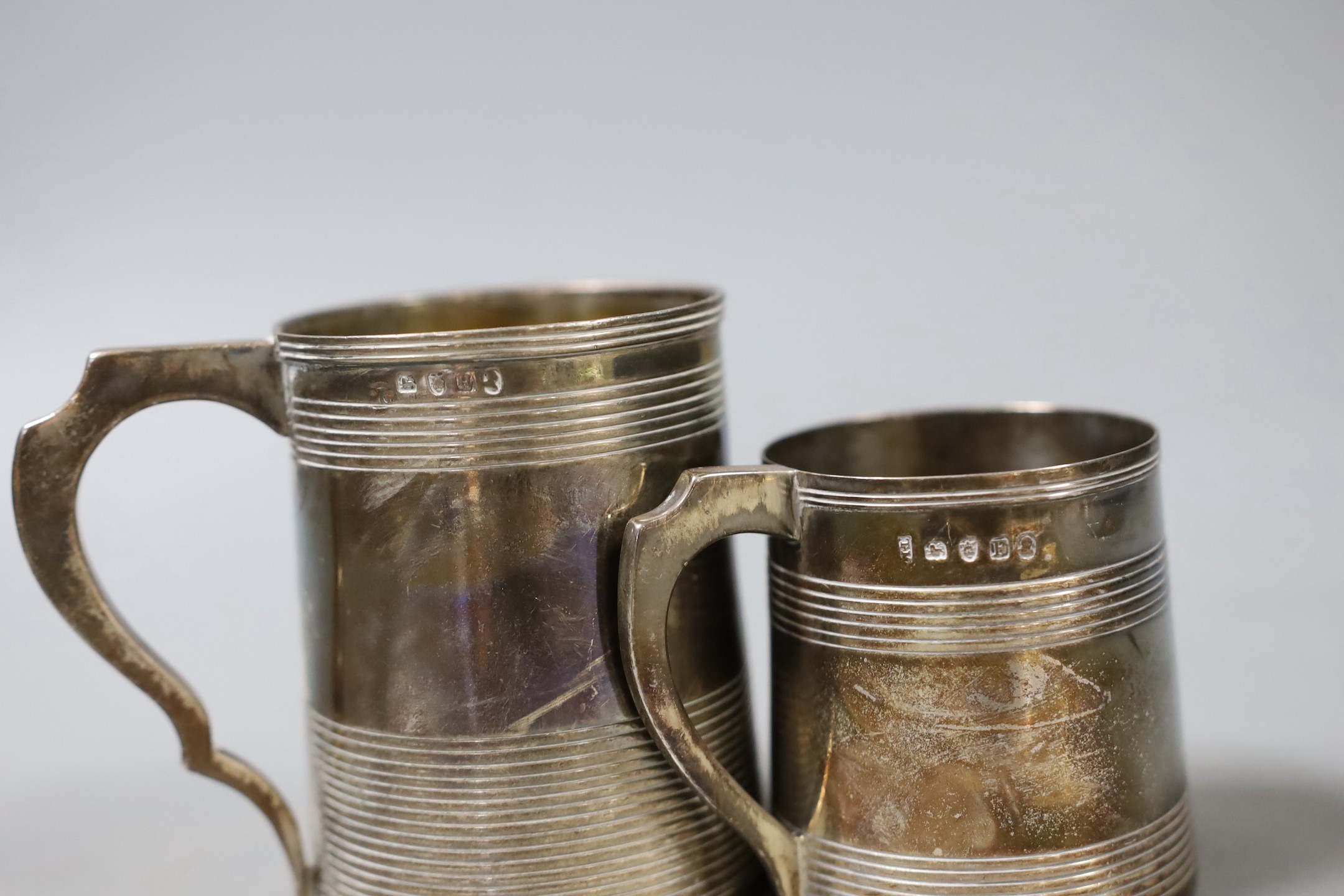 Two George III silver christening mugs, both with reeded bands, Thomas Meriton, London, 1801, 62mm and Charles Chesterman II, London, 1803, 83mm, the latter with later? engraved initials, 7.5oz.